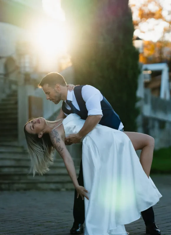 Novios realizando un dip romántico en sus bailes de boda al aire libre, con luz de atardecer