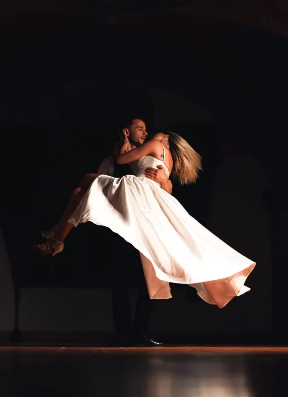 Novio levantando a la novia en el aire en una figura de baile durante baile de boda
