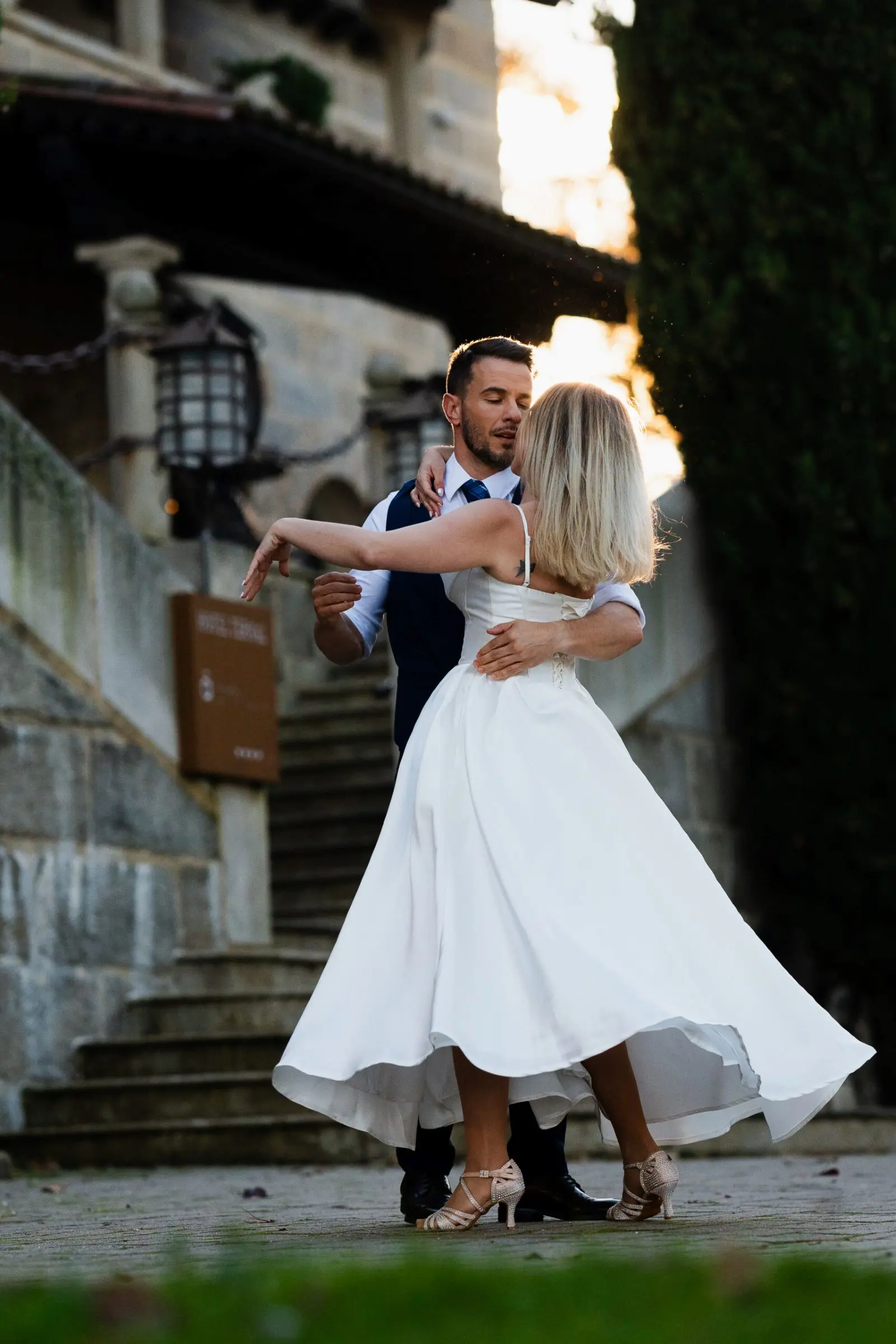 Novios bailando al aire libre con el vestido de la novia en movimiento.
