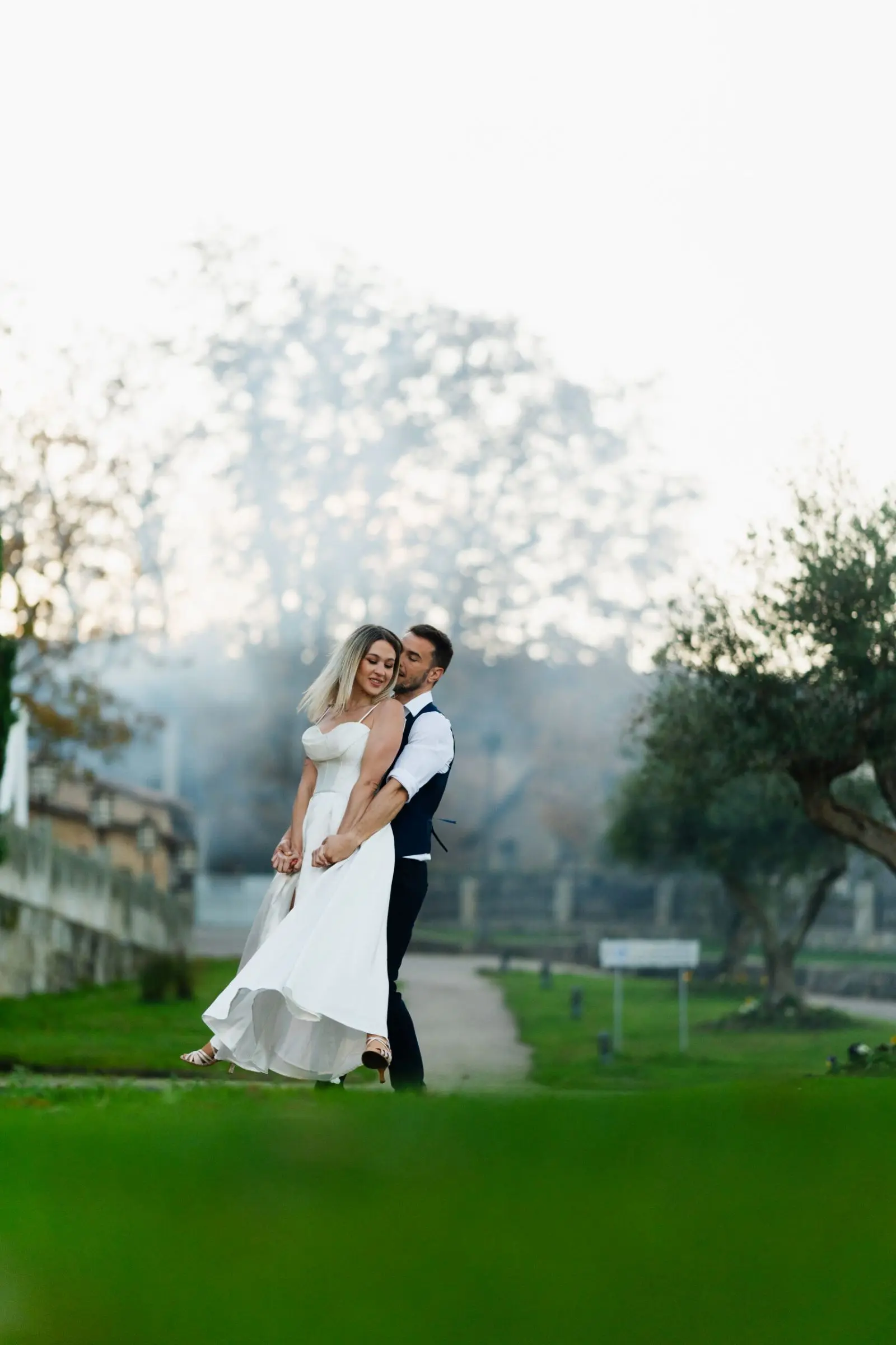 Novios bailando al aire libre en posición abrazada