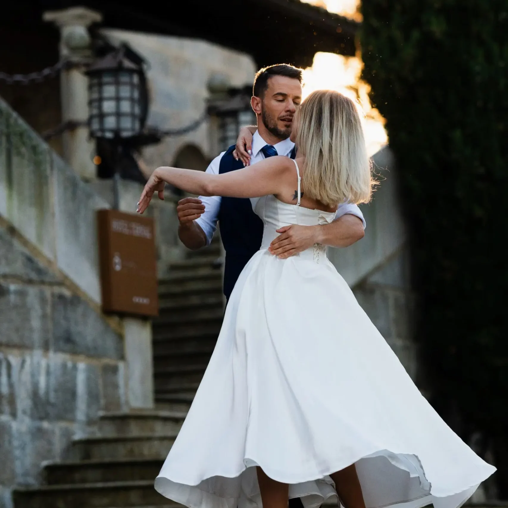 Novios bailando al aire libre con el vestido de la novia en movimiento.