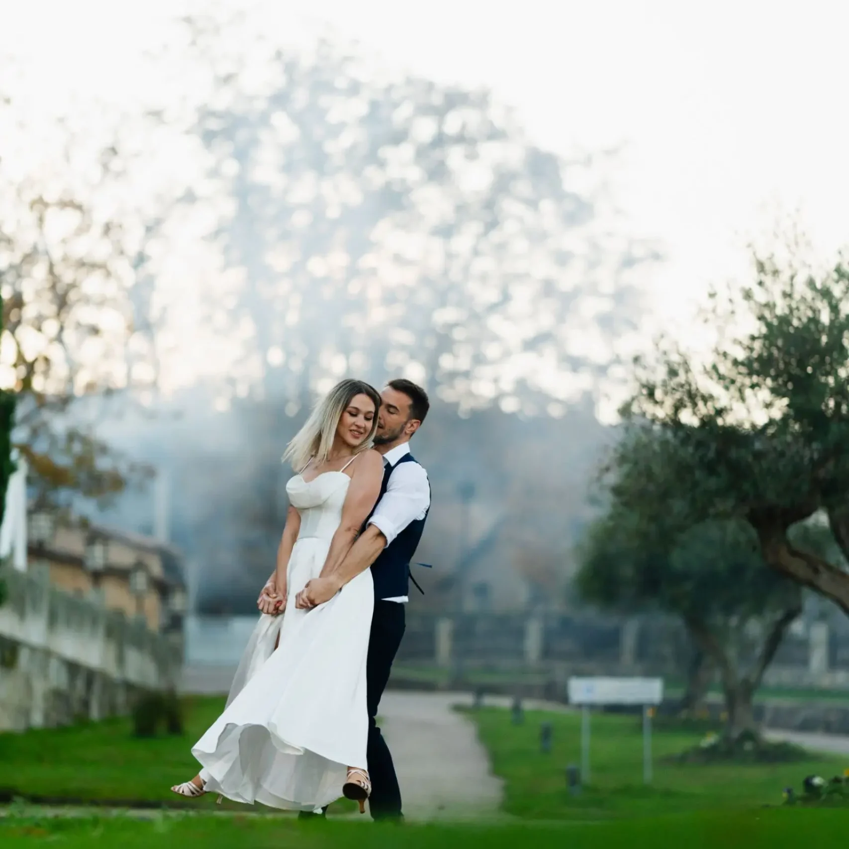 Novios bailando al aire libre en posición abrazada